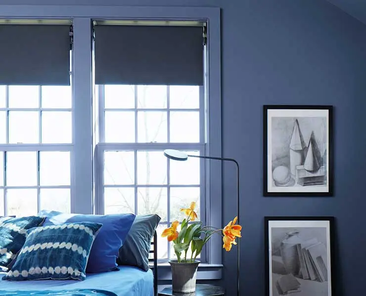 Синие рулонные шторы на белых окнах гармонируют со стенами в цвете Blue Nova